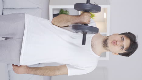 Vertical-video-of-Man-working-out-arm-muscle-with-dumbbells.